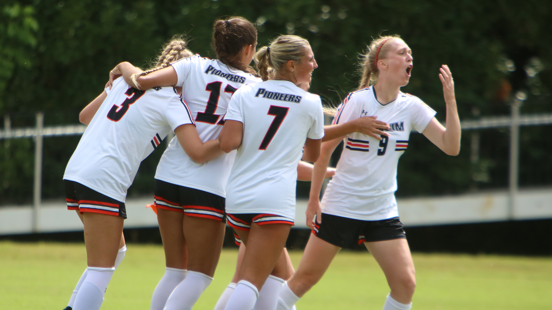 Alexis Roessler (right) celebrates with her teammates after giving the Pioneers a 1-0 lead (photo by Dom Donnelly)